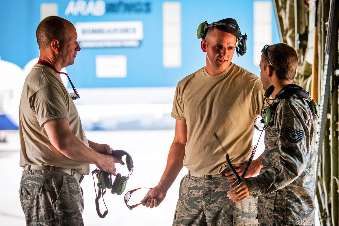 U.S. Air Force Reserve Tech. Sgt. Christopher Holmes, aircraft electrician, Staff Sgt. Nolan Bartow, dedicated crew chief, and Tech. Sgt. Jimmie McDougall, crew chief, discuss the day’s events in Amman, Jordan on April 15, 2018.