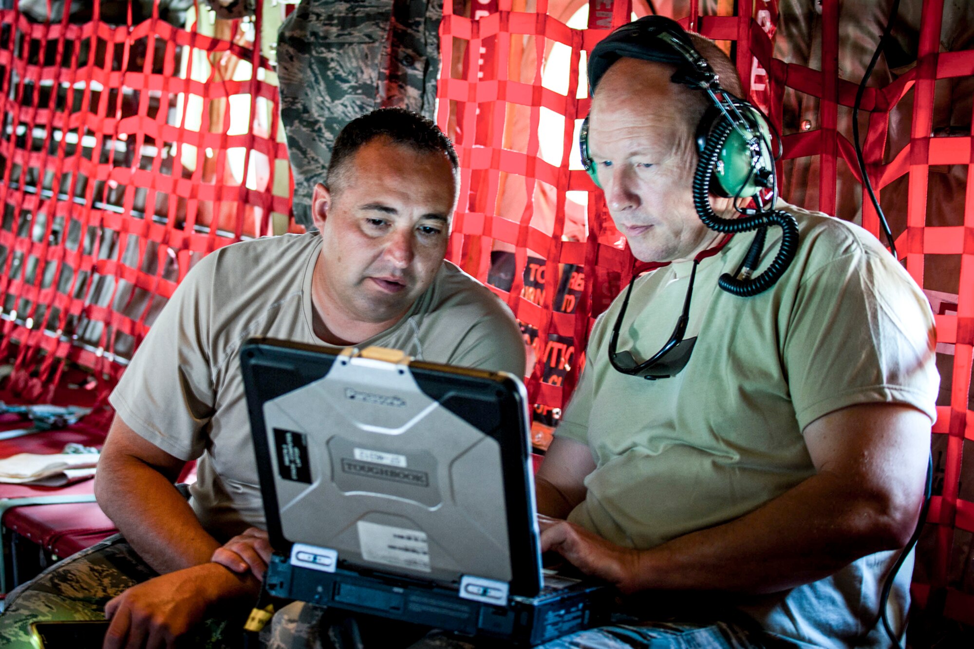 U.S. Air Force Reserve Tech. Sgt. Jimmy Myers, propulsion technician, and Tech. Sgt. Christopher Holmes, aircraft electrician, check technical orders in Amman, Jordan, April 15, 2018.