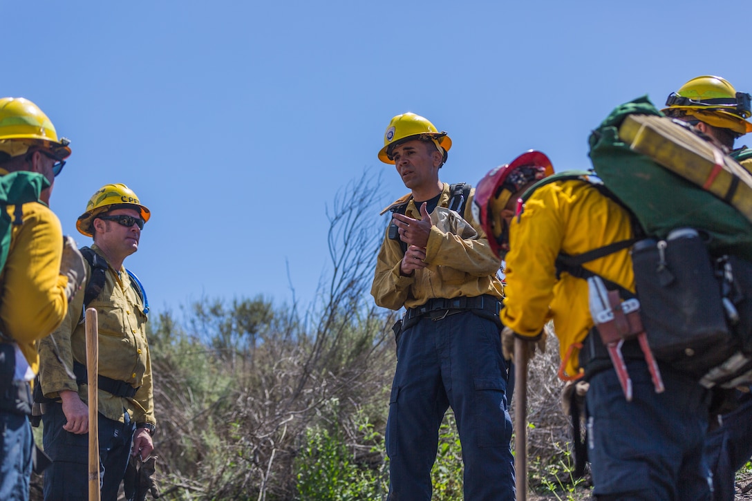 Firefighter Robert Wood, Station 3, Camp Pendleton Fire Department, leads debrief after conducting wild land fire refresher training 130 (WRT) at a mutual threat zone, April 16, 2018. The annual training, held every spring, revolves around a simulated wildfire that the firefighters must work together to contain. After the drill, participants discussed which elements went well as well as areas for improvement to ensure readiness for the upcoming fire season. (U.S. Marine Corps photo by Lance Cpl. Kerstin Roberts)