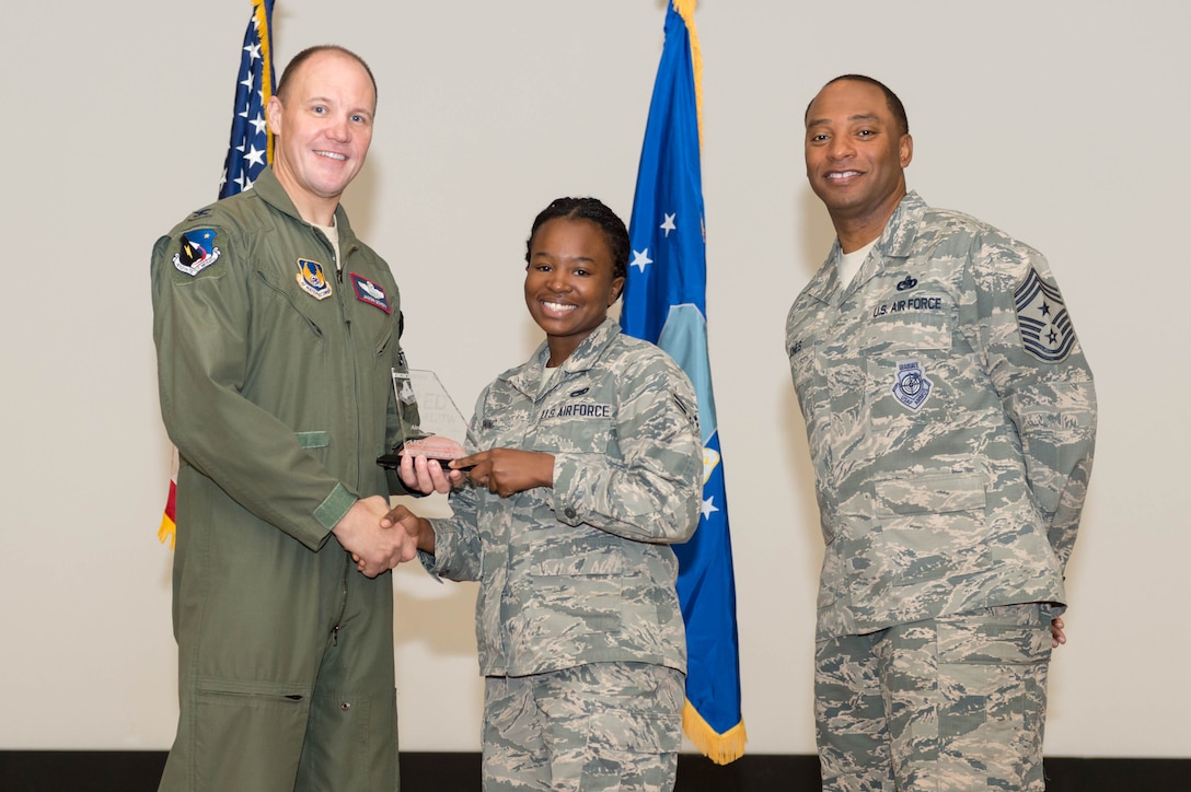 From left: Col. Jason Schott, 412th Test Wing vice commander, presents Airman 1st Class Tumarow Morning, 412th Maintenance Group, with the 412th TW Airman of the Quarter award, along with Chief Master Sgt. Roosevelt Jones, 412th TW command chief. The wing held its first quarter awards ceremony at the base theater May 3. (U.S. Air Force photo by Kyle Larson)