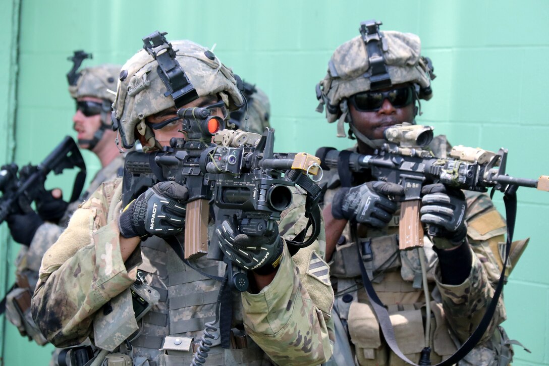 Three soldiers holding weapons move together.