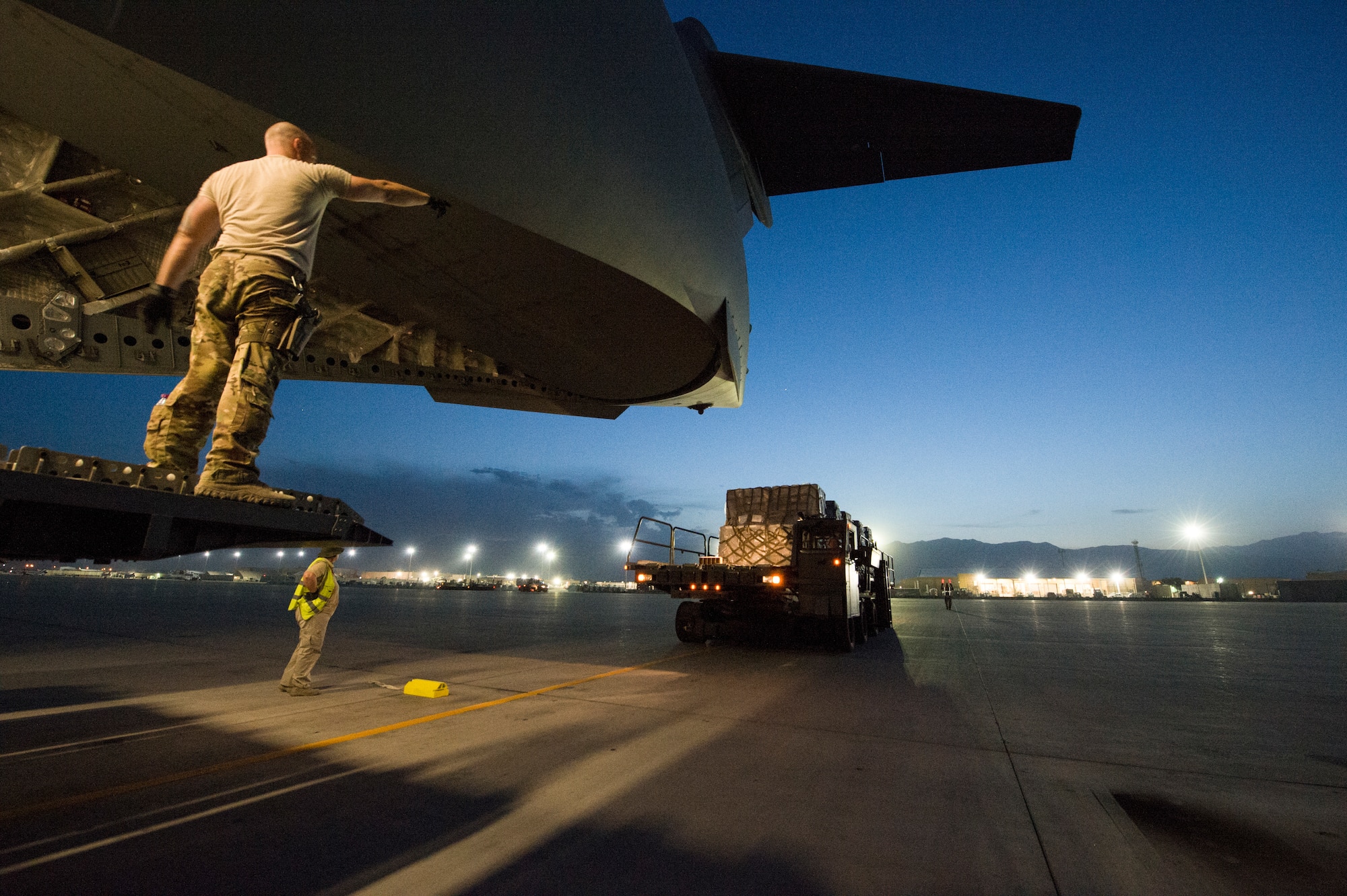 U.S. Air Force Senior Airman Jeremy Kosick, 816th Expeditionary Airlift Squadron instructor loadmaster, guides a K-loader back after off loading cargo onto a C-17 Globemaster III before a airdrop mission at Bagram Airfield, May 10, 2018. The C-17 transported troops and cargo to forward operating locations throughout the U.S. Central Command area of responsibility in support of Operation Freedom Sentinel mission. The C-17 is not only proficient in transporting troops and supplies, but can also perform tactical airlift and airdrop missions and transport ambulatory patients during aeromedical evacuations. (U.S. Air Force photo by Staff Sgt. Keith James)