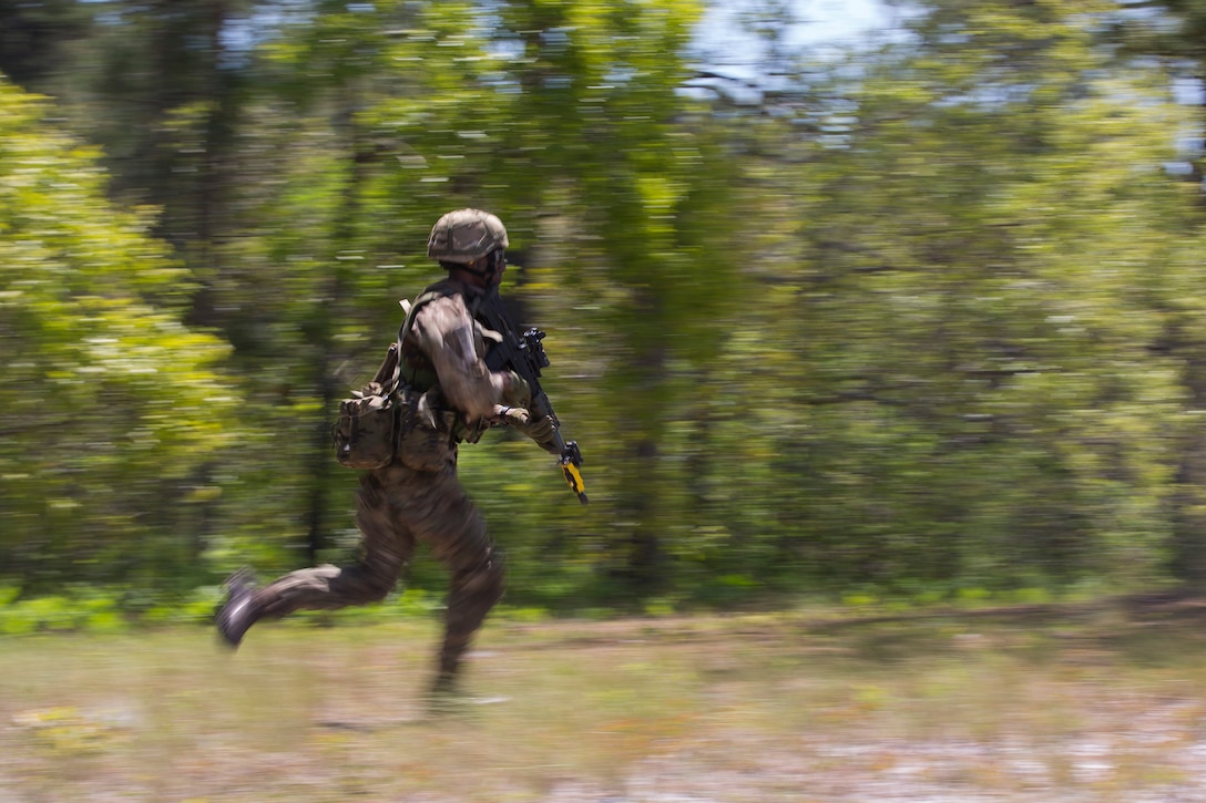A Soldier from the Royal Bermuda Regiment runs toward dirt mounds at the Junior Non-commissioned Officer Cadre on Marine Corps Base Camp Lejeune, N.C., May 4, 2018. The JNCO Cadre is a promotions course for promotion from Private Bandsman Drummer to Lance Corporal and is open to all Soldiers who have completed one year of service and have the recommendation of their company commander. This training requires additional drill nights and weekends and develops leadership, command skills, military knowledge and strengthens teamwork. (U.S. Marine Corps photo by Cpl. Juan Madrigal)