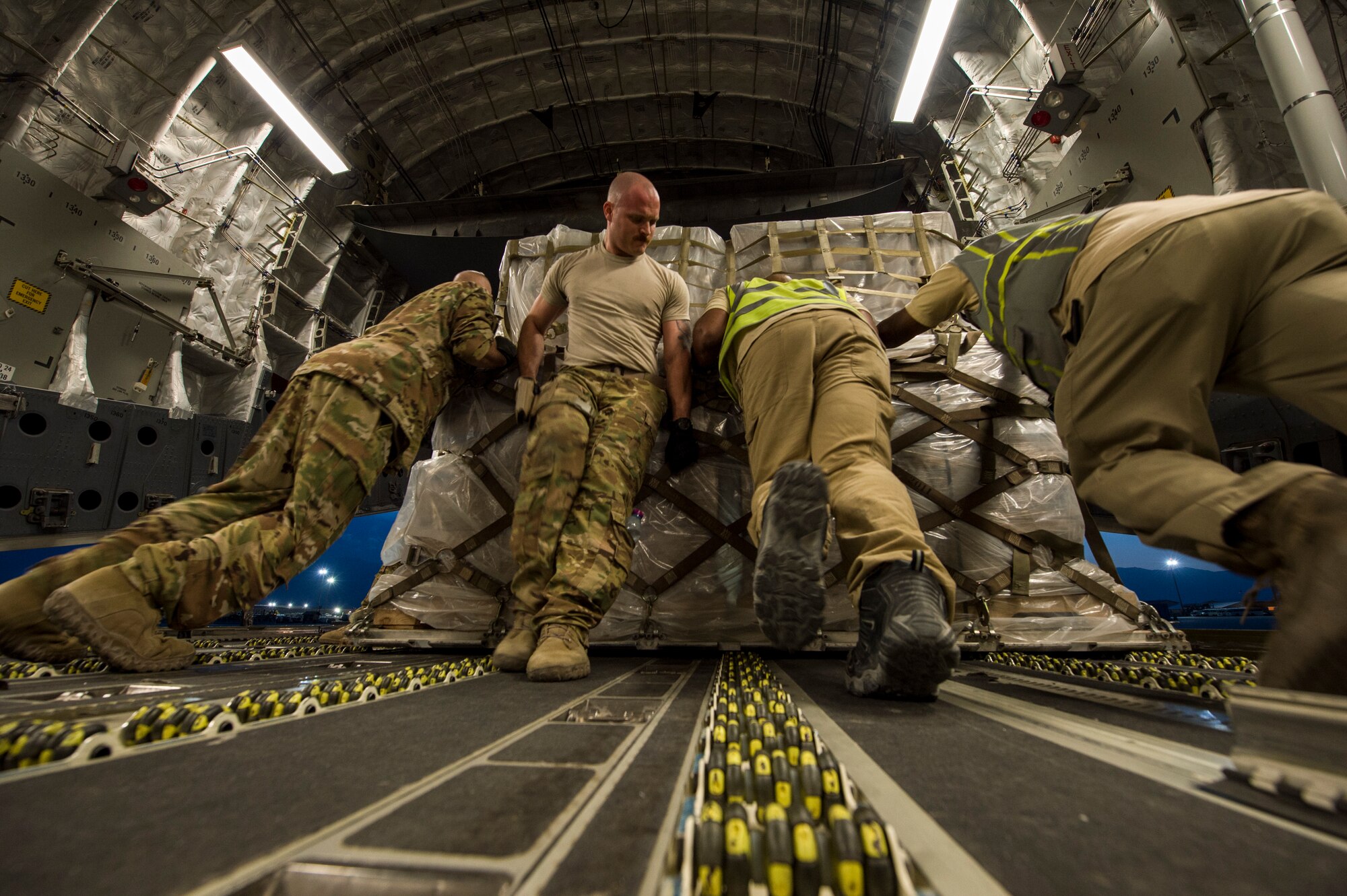U.S. Air Force loadmasters assigned to the 816th Expeditionary Airlift Squadron and air transportation personnel off load pallets from a C-17 Globemaster III at Bagram Airfield, Afghanistan, May 10, 2018. The C-17 transported troops and cargo to forward operating locations throughout the U.S. Central Command area of responsibility in support of Operation Freedom Sentinel mission. The C-17 is not only proficient in transporting troops and supplies, but can also perform tactical airlift and airdrop missions and transport ambulatory patients during aeromedical evacuations. (U.S. Air Force photo by Staff Sgt. Keith James)