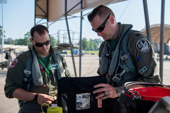 Capt. Bowman (right), 335th Fighter Squadron pilot, and 1st Lt. Kaiser, 335th FS weapon systems officer, check over the maintenance log of an F-15E Strike Eagle during exercise Razor Talon, May 11, 2018, at Seymour Johnson Air Force Base, North Carolina.
