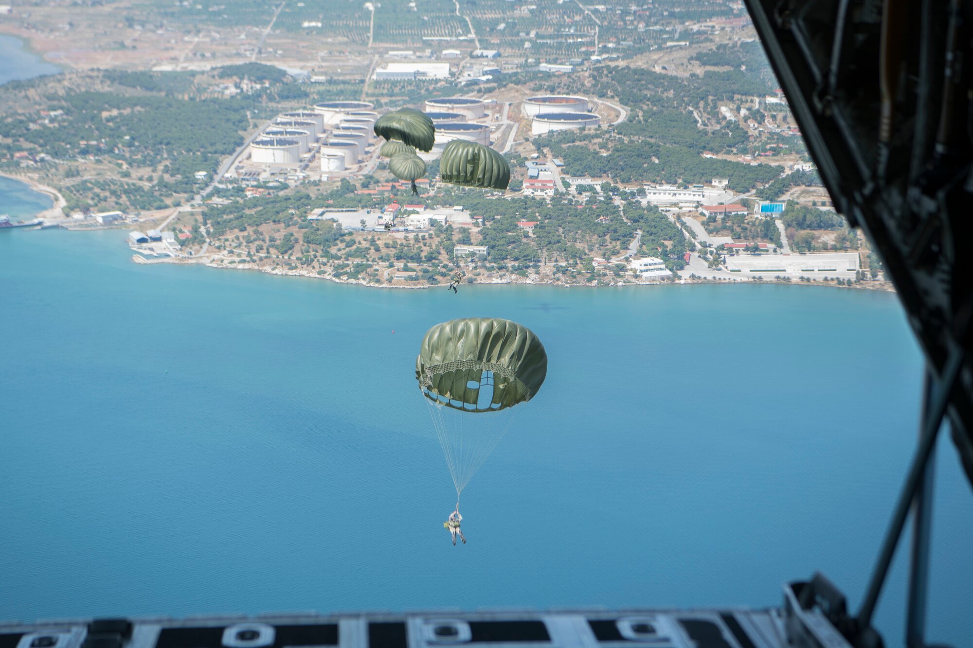 Hellenic paratroopers jump out of a U.S. Air Force C-130J Super Hercules during an exercise Stolen Cerberus V training mission in the skies near Elefsis Air Base, Greece, May 9, 2018. A U.S. Army jumpmaster verified all paratroopers parachutes were within U.S. restrictios prior to boarding and jumping from the aircraft. Combined exercises such as these enhance the interoperability capabilities and skills among allied and partner armed forces. (U.S. Air Force photo by Senior Airman Devin M. Rumbaugh)