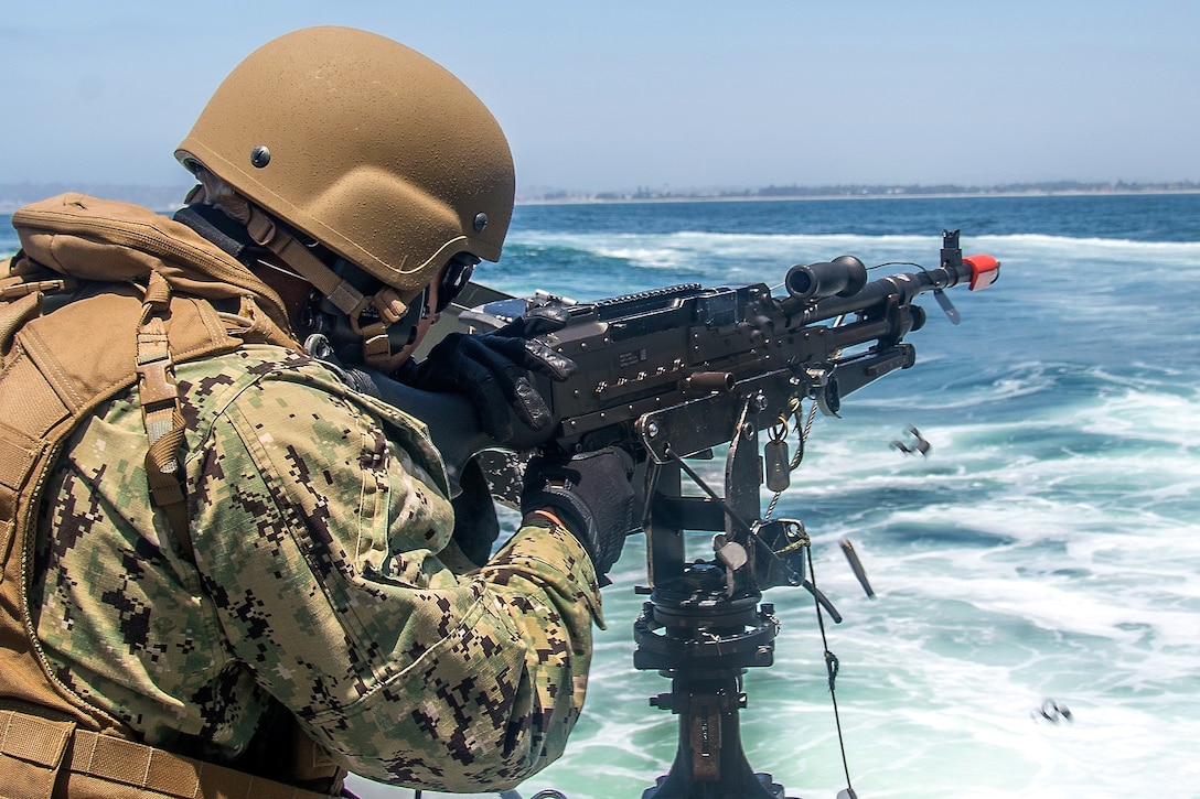 A sailor fires the M240 machine gun.