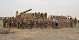 Participants of Engineer Week gather in front of an Assault Breaching Vehicle (ABV). Its purpose is to clear pathways through minefields. The other vehicle (right, rear) is called the Buffalo, and is used in route clearance missions.  The arm on the Buffalo is used to investigate any suspected or located improvised explosive devices (IED's).  The arm also allows Soldiers to safely destroy any located IED's. The 40th Brigade Engineer Battalion (BEB), hosted Engineer Week, from April 9-13.