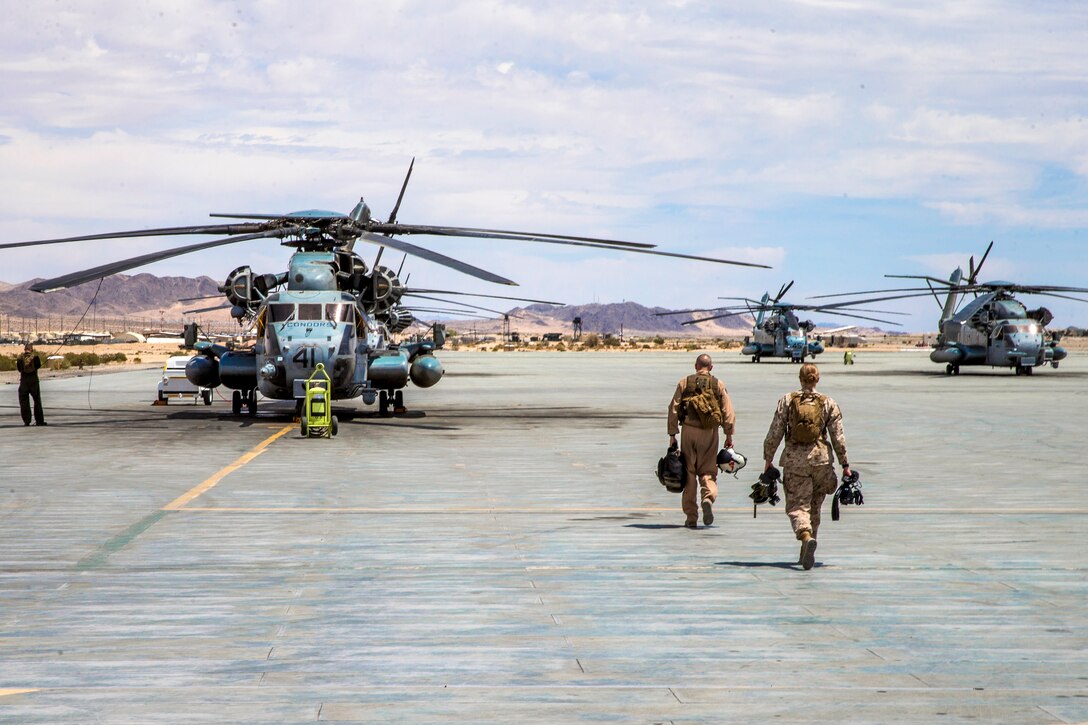 Marines walk toward a CH-53E Super Stallion helicopter.