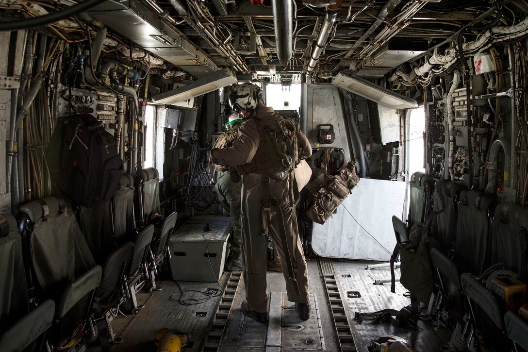 A Marine puts on his flak jacket before a flight.