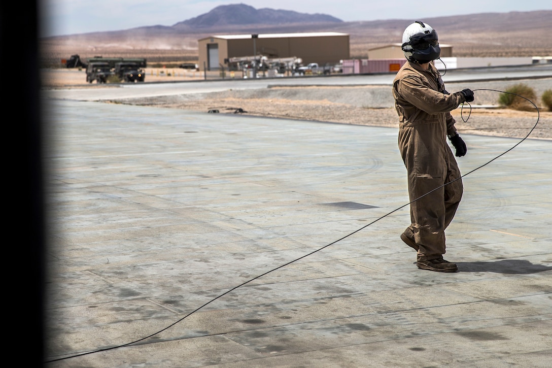 A Marine crew chief communicates with pilots before a flight.