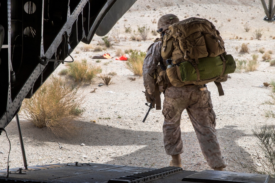 A Marine disembarks a CH-53E Super Stallion helicopter.