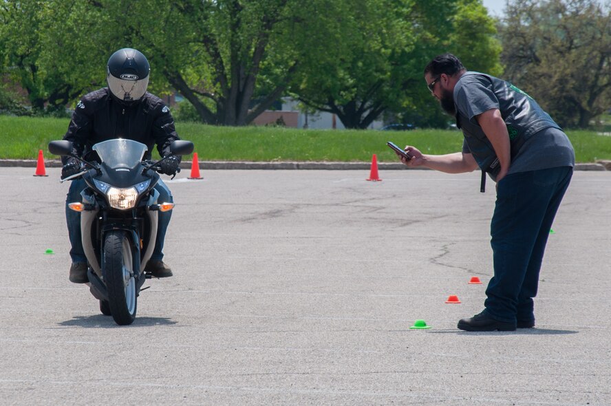 Retired master sergeant and Green Knights member Joseph "Smokey" Rivera times Staff Sgt. Ethan Cornell, a financial operations supervisor with the 88th Comptroller Squadron, during a slow ride contest as part of Wright-Patterson Air Force Base's Motorcycle Safety Day May 11, 2018.