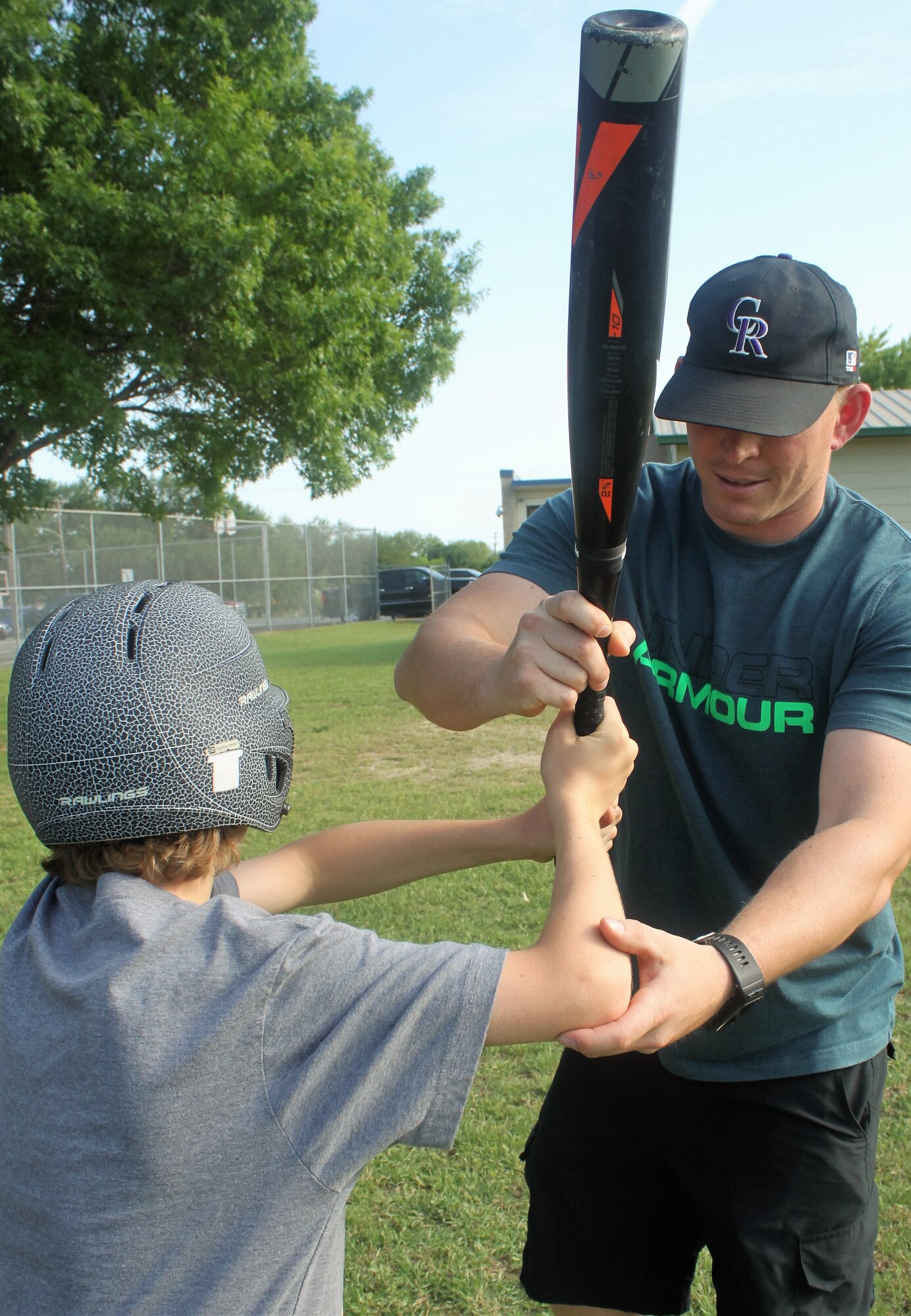 Master Sgt. Randy Alvis helps a member of his youth baseball team adjust his bat and swing during youth baseball practice. (U.S. Air Force photo by Debbie Gildea)