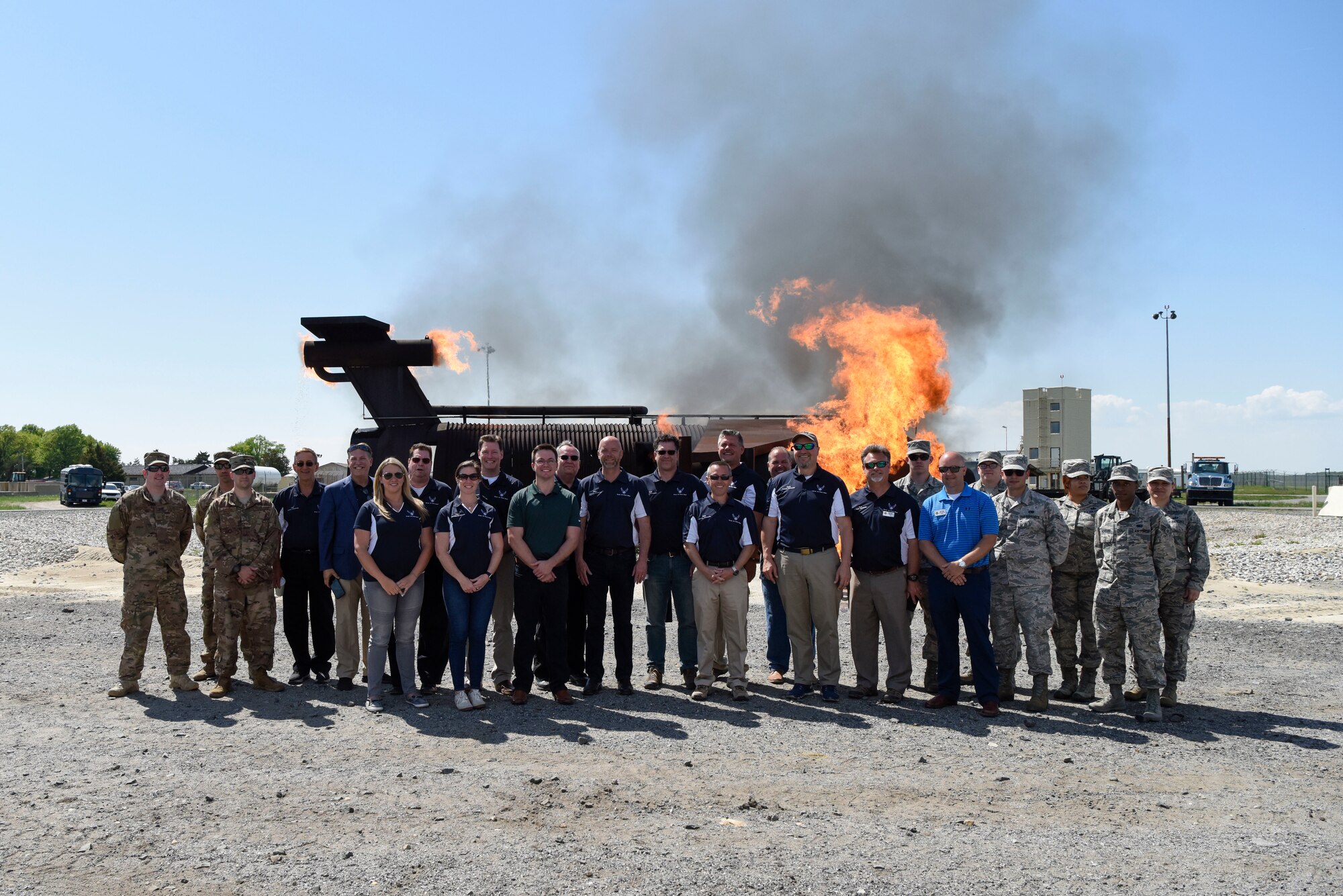 Honorary commanders of the 436th Airlift Wing pose for a photo in front of the aircraft fire training facilities during a tour May 9, 2018, at Dover Air Force Base, Del. The honorary commanders were given a closer look at the day-to-day life of the 436th Mission Support Group and the Airmen who work there. (U.S. Air Force photo by Airman 1st Class Zoe Wockenfuss)