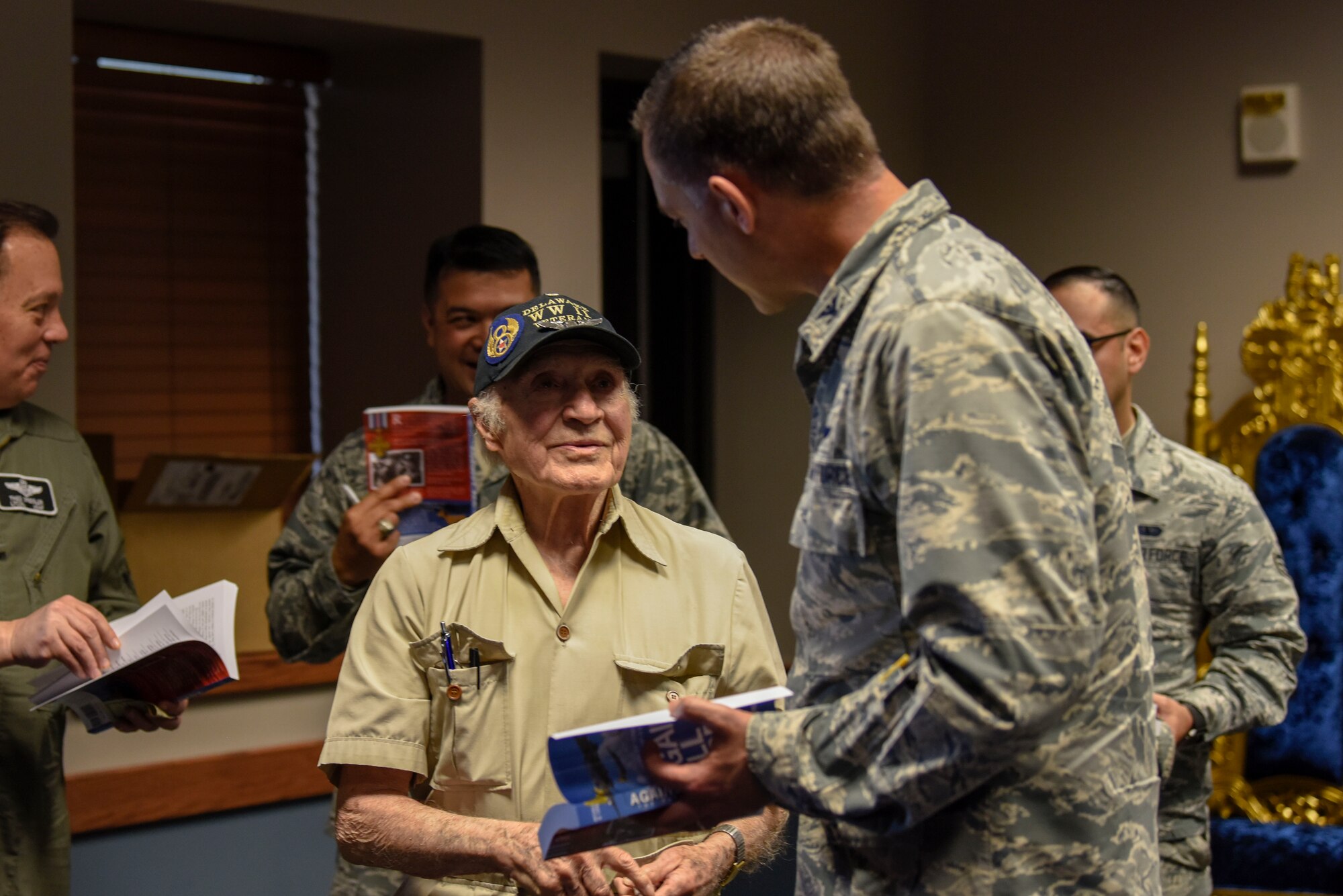 Col. Ethan Griffin, 436th Airlift Wing commander, gets his copy of “Against All Odds: The Firmani Story” signed by retired Army Air Corps 1st Lt. Ray Firmani, World War II B-17 pilot, during the quarterly Hangar Talk May 10, 2018, at Dover Air Force Base, Del. The book is an account of Firmani’s experiences as a pilot during World War II. (U.S. Air Force photo by Airman 1st Class Zoe M. Wockenfuss)