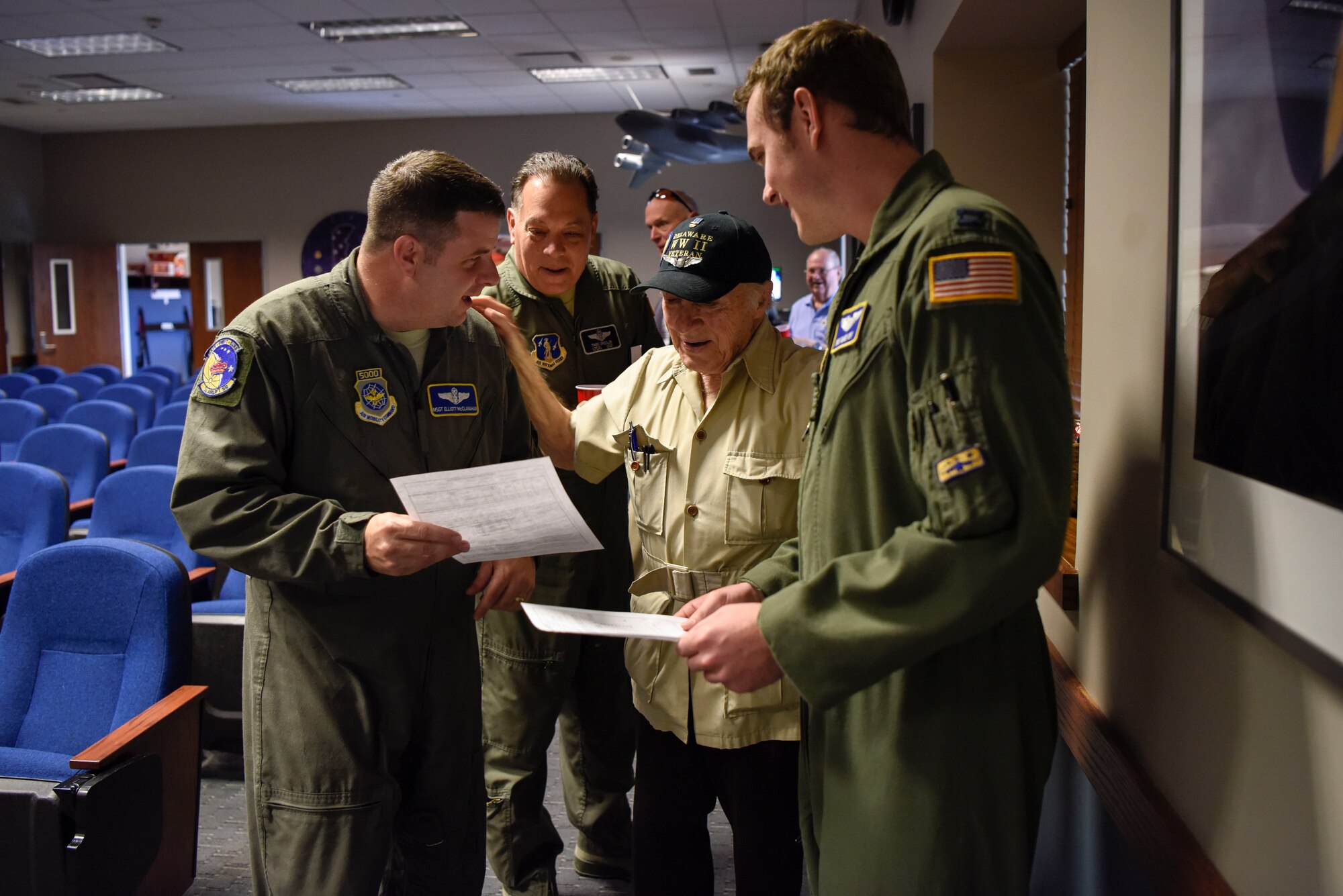 Master Sgt. Elliot McClanahan (left), 3rd Airlift Squadron loadmaster and Capt. Richard Gangloff, 3rd AS C-17 Globemaster III pilot, ask retired Army Air Corps 1st Lt. Ray Firmani, World War II B-17 pilot, to sign their flight authorizations May 10, 2018, after the quarterly Hangar Talk at Dover Air Force Base, Del. Flight authorizations give clearance for aircrew to fly missions and many are saved as keep-sakes of the flight. (U.S. Air Force photo by Airman 1st Class Zoe M. Wockenfuss)