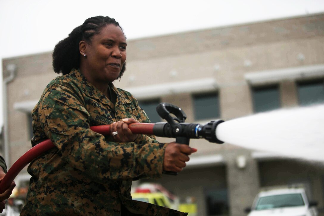 Sonja Broadus, wife of the Headquarters and Headquarters Squadron sergeant major, practices firefighting techniques during “Walk a Mile in Their Boots” at Marine Corps Air Station Miramar, Calif., May 11. “Walk a Mile in Their Boots” is an annual event that gives spouses the opportunity to experience some if the duties and responsibilities of their active duty counterparts. (U.S. Marine Corps photo by Lance Cpl. Mark A. Lowe/Released)