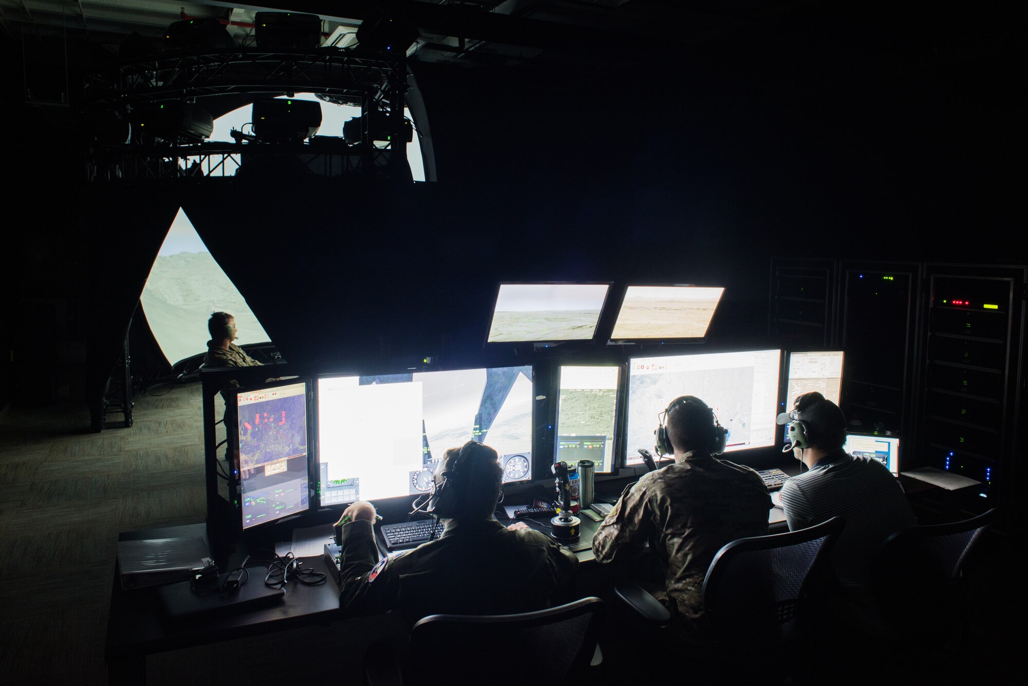 Instructors operate a 138th Combat Training Flight Air National Guard Advanced Joint Terminal Attack Control Simulator while a Tactical Air Control Party specialist calls in an airstrike during a simulated mission at Will Rogers Air National Guard Base in Oklahoma City, May 9, 2018. The simulator has saved the Air National Guard and Air Combat Command both time and money while ensuring the readiness of battlefield Airmen. (U.S. Air National Guard photo by Staff Sgt. Tyler Woodward)