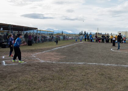Jon Peterson, 2018 Alaska Boys and Girls Club of America Military Youth of the Year, throws the first ceremonial pitch of the season to Gavin Shafer, 11, during the Little League opening day ceremony at Joint Base Elmendorf-Richardson, Alaska, May 12, 2018. Every year the coach of the year and teen of the year are selected for the ceremonial first pitch to kick off the season.