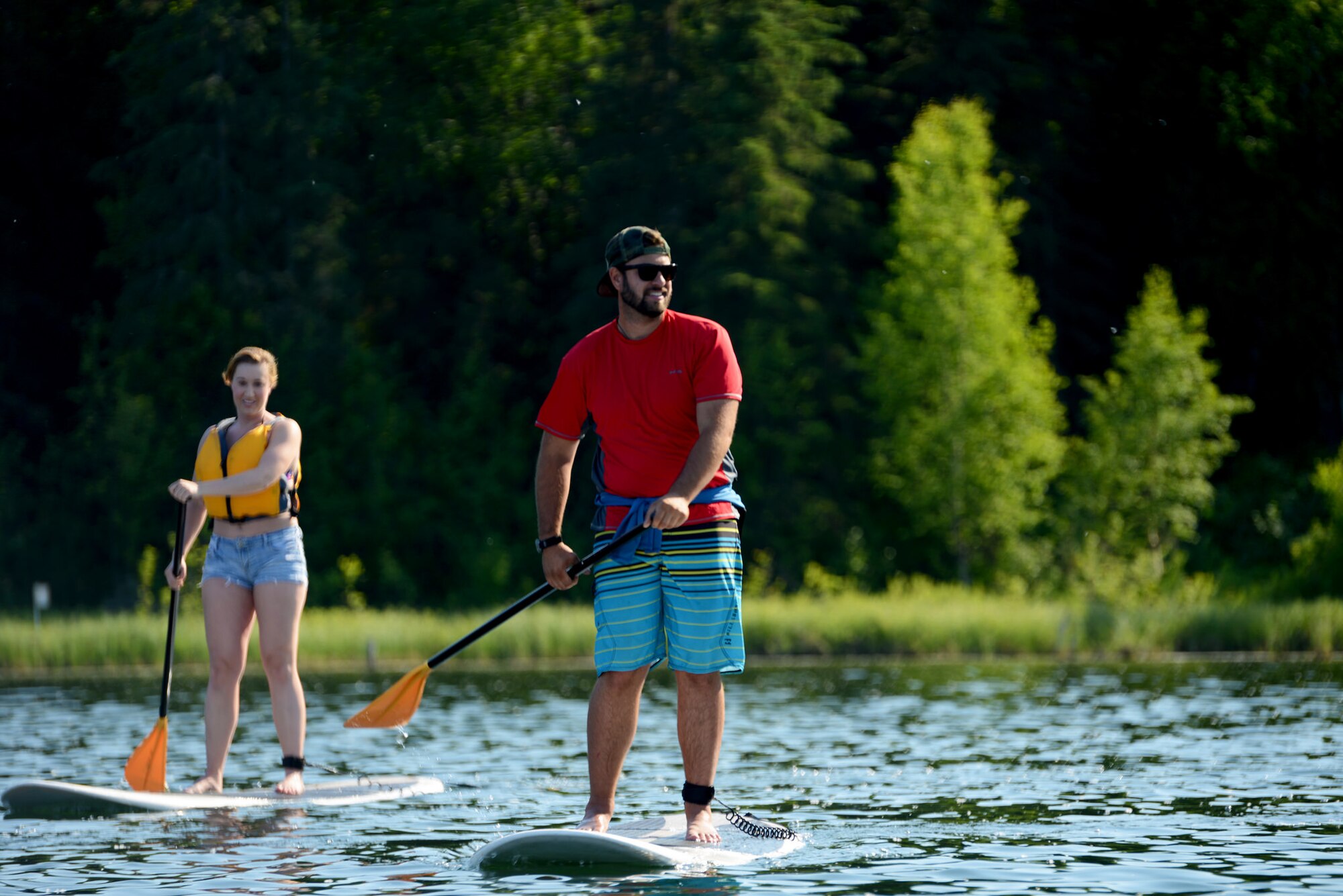 Trevor Bird, paddle board instructor at Otter Lake Lodge, and Senior Airman Sheriah Colcleaser, with the 673d Medical Group, paddle toward the center of Otter Lake at Joint Base Elmendorf-Richardson, Alaska, June 22, 2015. JBER is scheduled to host an Airmen Appreciation Day at Otter Lake at 2 p.m., June 1, 2018. The event invites senior airmen and below, plus one guest each, to participate in an afternoon of free food and activities. Free activities include paintball, kayaking, paddle boats, stand-up paddle boards, inflatable jousting, bubble ball suit soccer, inflatable darts, volleyball, horseshoes, video games and card games.