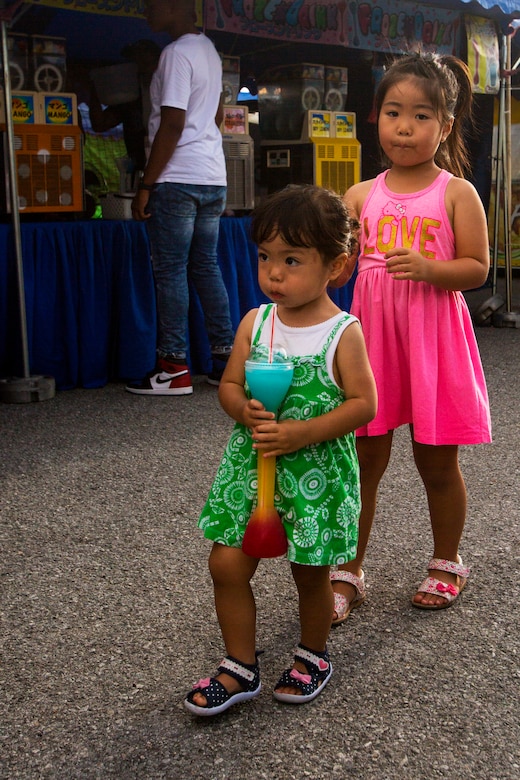 Children enjoy a frozen drink while walking through the game tents during Foster Fest May 12 aboard Camp Foster, Okinawa, Japan. The annual festival allowed members of the community to enjoy food, games and music. More than 13,000 people attended the two-day festival. (U.S. Marine Corps photo by Pfc. Nicole Rogge)