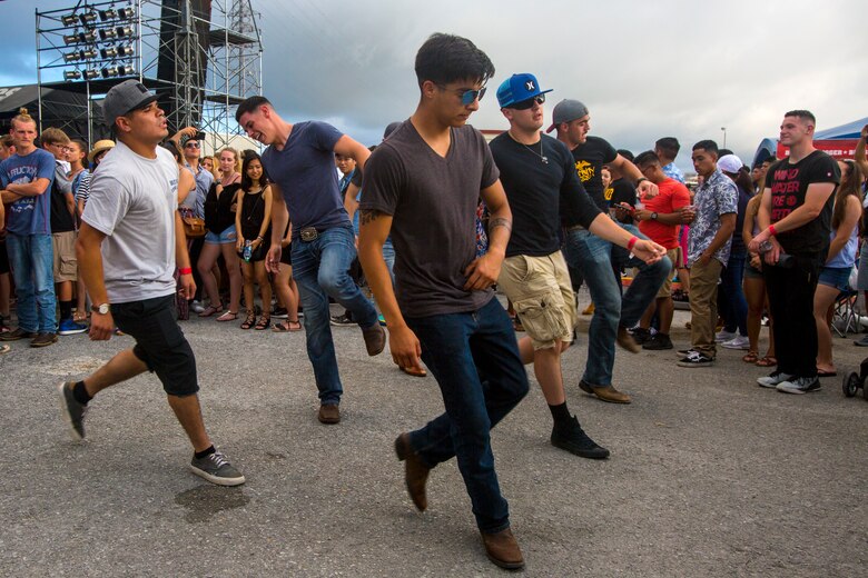 Marines line dance to a local band performance during Foster Fest May 12 aboard Camp Foster, Okinawa, Japan. The annual festival allowed members of the community to enjoy food, games and music. More than 13,000 people attended the two-day event.  (U.S. Marine Corps photo by Pfc. Nicole Rogge)