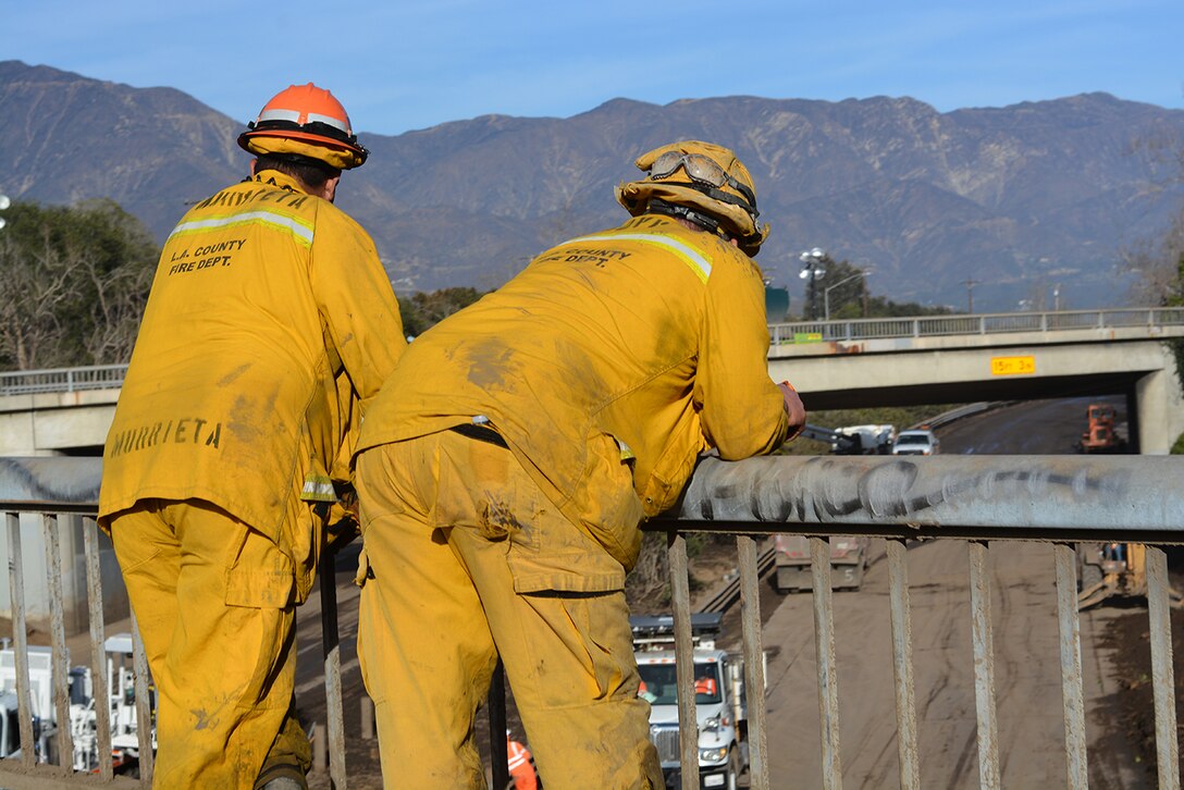 Murrieta Fire and Rescue personnel take a break while looking out over the 101 Freeway Jan. 18 in Montecito, California. The freeway below the men was still being cleared of mud and debris from the Jan. 9 mudslide in Montecito.