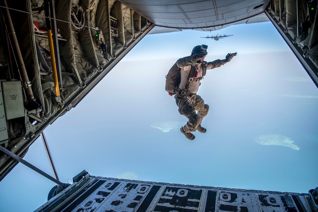 An airman jumps out of the back of the aircraft.
