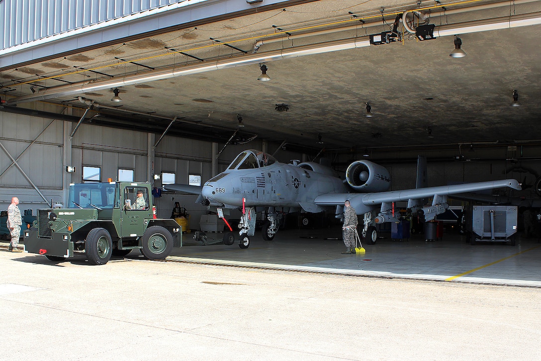 Airmen tow an A-10 Thunderbolt II aircraft.