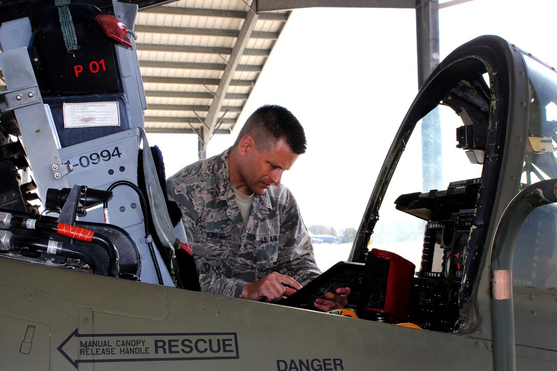 An airman checks a technical order while performing routine maintenance.