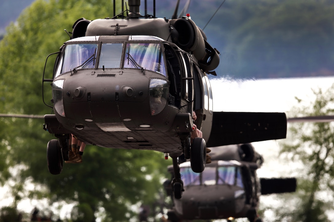 Two Army UH-60 Black Hawk helicopters take off.