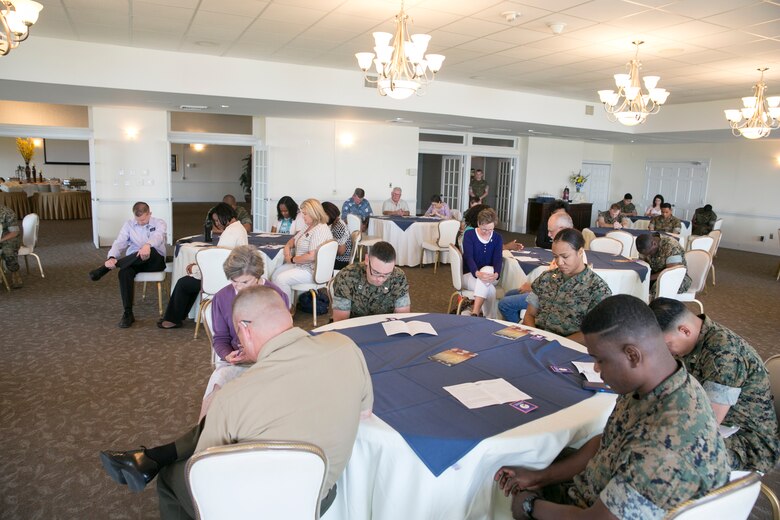 Members of the community and service members on Marine Corps Air Station New River bow their heads while the food they are to receive is blessed during the National Day of Prayer at the Officers' Club on MCAS New River, May 3. The National Day of Prayer is an annual event taking place on the first Thursday of May. (U.S. Marine Corps photo by Lance Cpl. Nicholas Lubchenko)