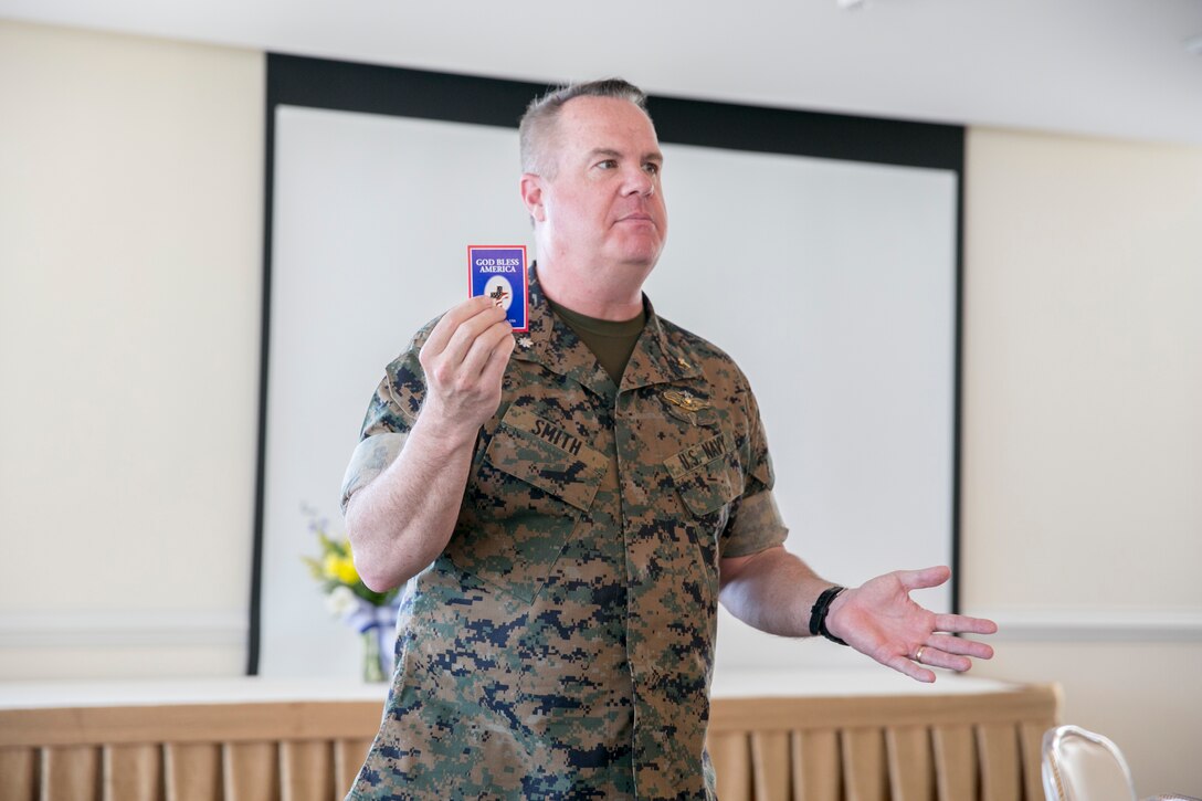Patrick Smith, senior chaplain, Marine Corps Air Station New River, displays a commemorative pin to the attendees during the National Day of Prayer at the Officers' Club on MCAS New River, May 3.  The National Day of Prayer is open to all people of all faiths to pray for the nation. (U.S. Marine Corps photo by Lance Cpl. Nicholas Lubchenko)