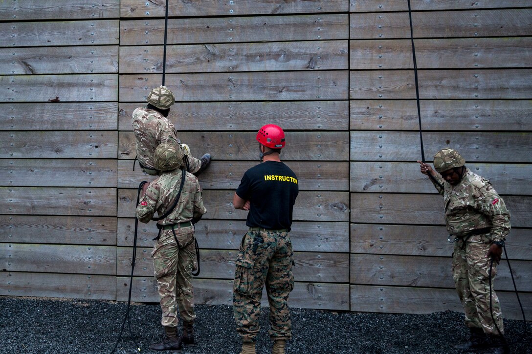 Soldiers of the Royal Bermuda Regiment train on rappelling as Capt. Mark Deal, ropes and recovery officer in charge for Expeditionary Operations Training Group, II Marine Expeditionary Force, supervises the Soldiers belaying at Stone Bay on Marine Corps Base Camp Lejeune on May 8, 2018. The regiment was at MCB Camp Lejeune for a two week evolution, the Junior Noncommissioned Officer Cadre, which includes scenario-based exercises, rappelling, section attacks and section battle drills. (U.S. Marine Corps photo by Lance Cpl. Dominique Fisk)