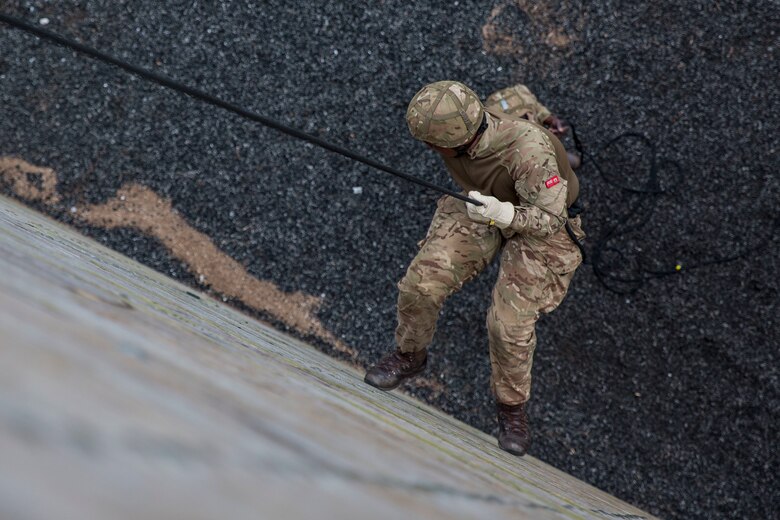 A soldier with the Royal Bermuda Regiment rappels down the rappel tower at Stone Bay on Marine Corps Camp Lejeune on May 8, 2018.  The regiment was at MCB Camp Lejeune for a two week evolution, the Junior Noncommissioned Officer Cadre, which includes scenario-based exercises, rappelling, section attacks and section battle drills. (U.S. Marine Corps photo by Sgt. Melodie Snarr)