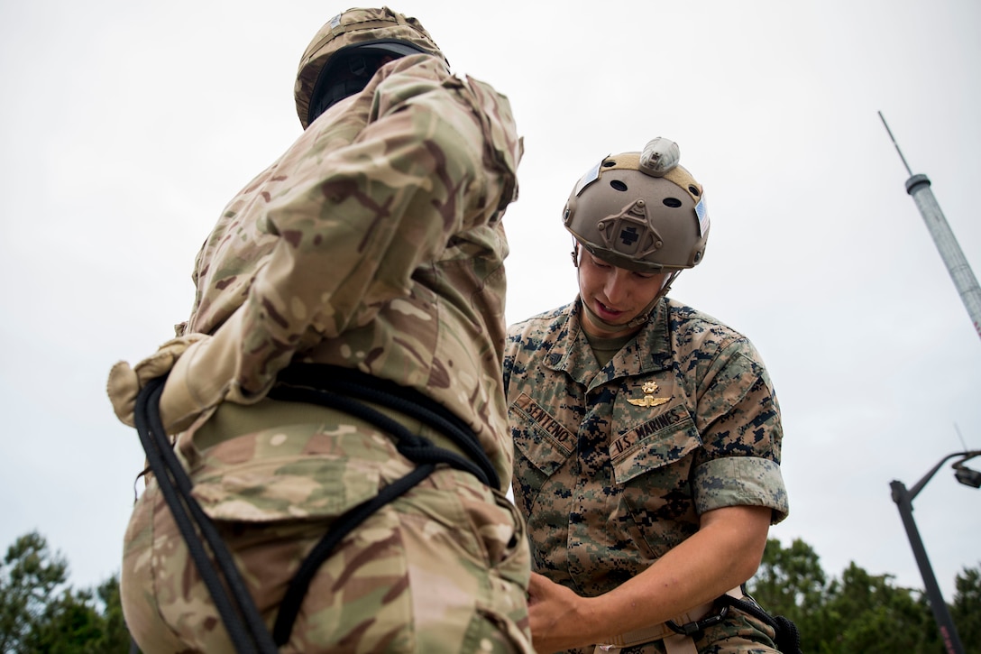 A soldier with the Royal Bermuda Regiment is instructed on rappelling by Sgt. Johnny Senteno, reconnaissance man, 2nd Reconnaissance Battalion, 2nd Marine Division, at Stone Bay on Marine Corps Camp Lejeune on May 8, 2018. The regiment was at MCB Camp Lejeune for a two week evolution, the Junior Noncommissioned Officer Cadre, which is a course for promotion for the Soldiers in the regiment and is open to all Soldiers who have completed one year of service and have the recommendation of their company commander. (U.S. Marine Corps photo by Sgt. Melodie Snarr)