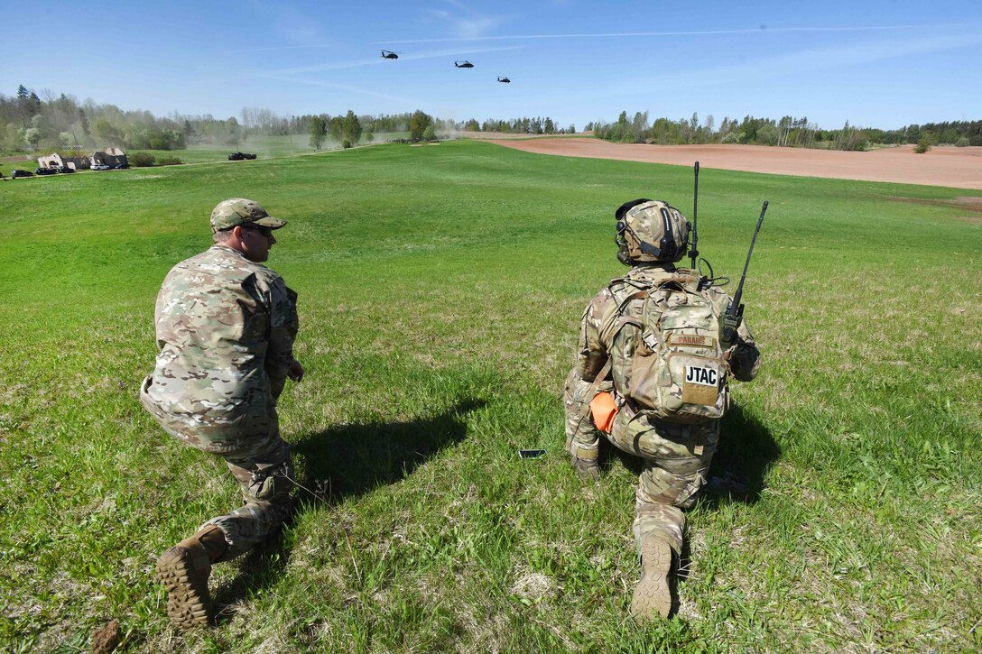 Airmen observe as UH-60 Black Hawk helicopters take off.