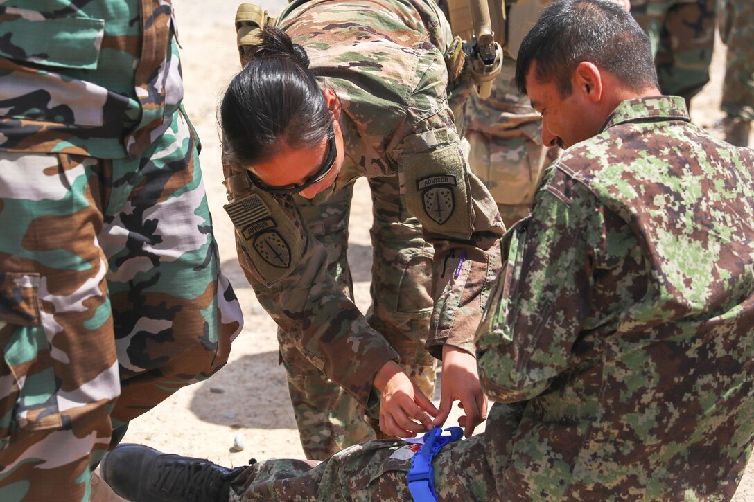 A U.S. soldier adjusts a tourniquet on a role-playing casualty.