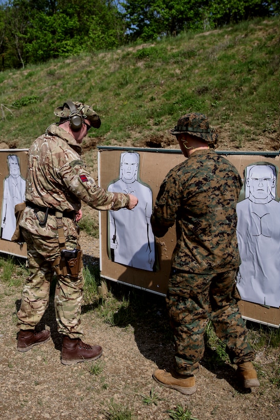 British Army Capt. Timothy D. Harnett (left), commando with 131 Commando Squadron Royal Engineers, British Army, inspects his target as U.S. Marine Cpl. Thomas J. Smarch Jr. (right), range coach with Engineer Support Company, 6th Engineer Support Battalion, 4th Marine Logistics Group, gives feedback after shooting during exercise Red Dagger at Fort Indiantown Gap, Pa., May 15, 2018.