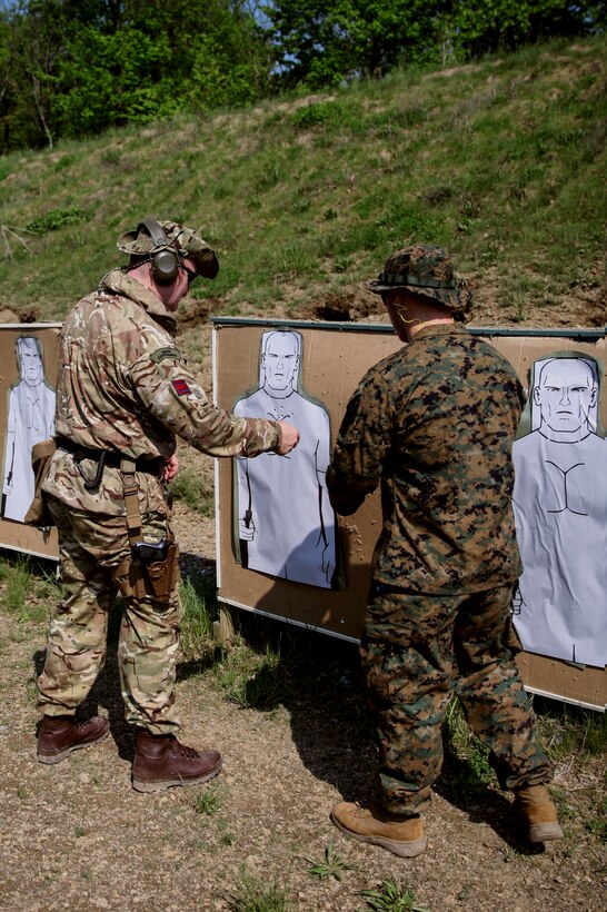 British Army Capt. Timothy D. Harnett (left), commando with 131 Commando Squadron Royal Engineers, British Army, inspects his target as U.S. Marine Cpl. Thomas J. Smarch Jr. (right), range coach with Engineer Support Company, 6th Engineer Support Battalion, 4th Marine Logistics Group, gives feedback after shooting during exercise Red Dagger at Fort Indiantown Gap, Pa., May 15, 2018.