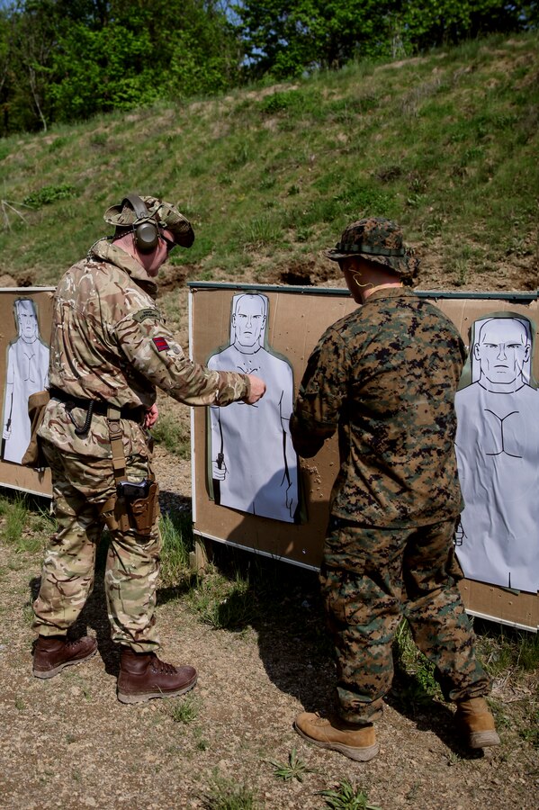 British Army Capt. Timothy D. Harnett (left), commando with 131 Commando Squadron Royal Engineers, British Army, inspects his target as U.S. Marine Cpl. Thomas J. Smarch Jr. (right), range coach with Engineer Support Company, 6th Engineer Support Battalion, 4th Marine Logistics Group, gives feedback after shooting during exercise Red Dagger at Fort Indiantown Gap, Pa., May 15, 2018. Exercise Red Dagger is a bilateral training exercise that gives Marines an opportunity to exchange tactics, techniques and procedures as well as build working relationships with their British counterparts. (U.S. Marine Corps photo by Sgt. Melanie Wolf/Released)