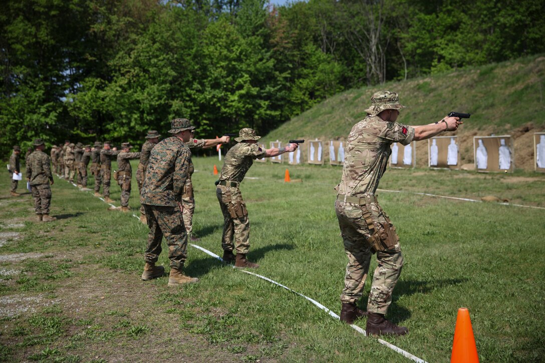 U.S. Marine Cpl. Thomas J. Smarch Jr., range coach with Engineer Support Company, 6th Engineer Support Battalion, 4th Marine Logistics Group, coaches the firing line of integrated Marines with 6th ESB and British commandos with 131 Commando Squadron Royal Engineers, British Army, at the pistol range during exercise Red Dagger at Fort Indiantown Gap, Pa., May 15, 2018.