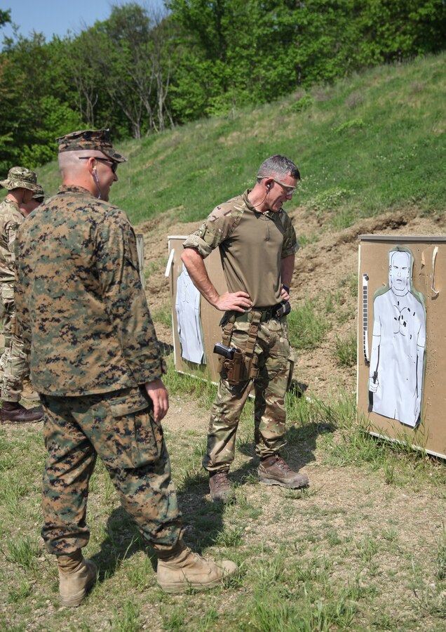 British Army Pte. Anthony Rice (right), commando with 131 Commando Squadron Royal Engineers, British Army, inspects his target as U.S. Marine Sgt. Steven J. Fries (left), range coach with Engineer Support Company, 6th Engineer Support Battalion, 4th Marine Logistics Group, gives feedback after shooting at the pistol range during exercise Red Dagger at Fort Indiantown Gap, Pa., May 15, 2018. Exercise Red Dagger is a bilateral training exercise that gives Marines an opportunity to exchange tactics, techniques and procedures as well as build working relationships with their British counterparts. (U.S. Marine Corps photo by Sgt. Melanie Wolf/Released)