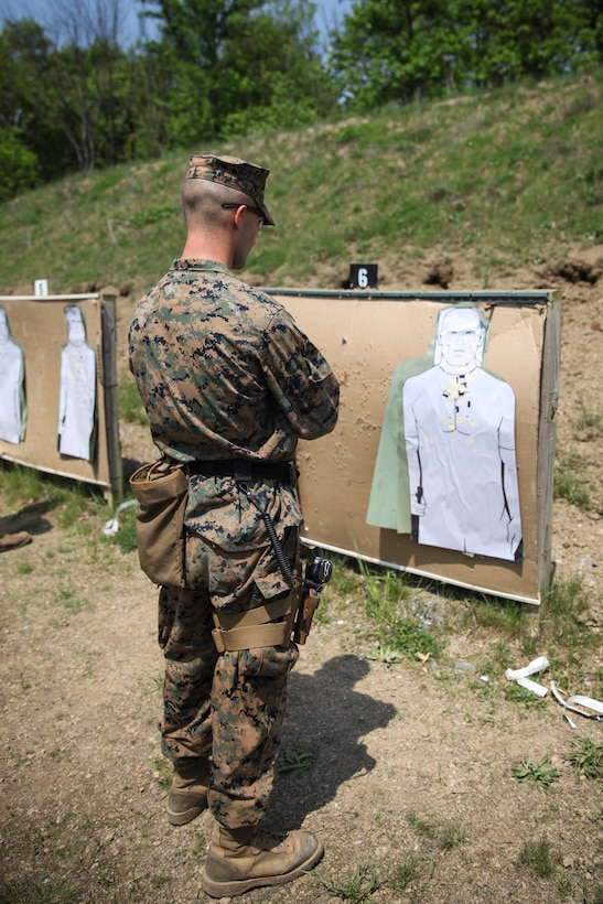 U.S. Marine Lance Cpl. Sean D. Glackin, heavy equipment operator with Bridge Company B, 6th Engineer Support Battalion, 4th Marine Logistics Group, inspects his target after shooting at the pistol range during exercise Red Dagger at Fort Indiantown Gap, Pa., May 15, 2018.