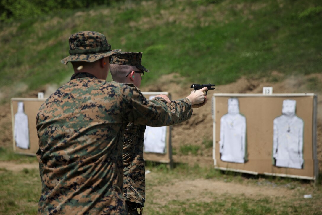 U.S. Marine Cpl. Thomas J. Smarch Jr., range coach with Engineer Support Company, 6th Engineer Support Battalion, 4th Marine Logistics Group, coaches U.S. Marine Lance Cpl. Ryan W. Carlson, field radio operator with H&S Co., on the firing line at the pistol range during exercise Red Dagger at Fort Indiantown Gap, Pa., May 15, 2018.