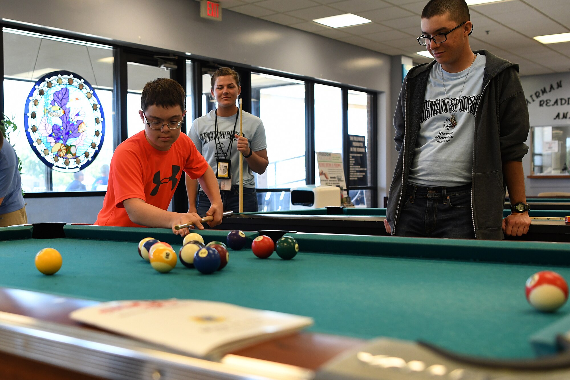 Easton Slutz, District 5 Special Olympics Mississippi athlete, plays pool with U.S. Air Force Airmen Kaimryn Hursch and Gabriel Agostini-Mesa, 336th Training Squadron students, during SOMS in the Levitow Training Support Facility at Keesler Air Force Base, Mississippi, May 11, 2018. On the first day of SOMS, Slutz, Agostini-Mesa and Hursch spent the day getting to know each other by playing pool, basketball and dominoes. (U.S. Air Force photo by Airman 1st Class Suzie Plotnikov)