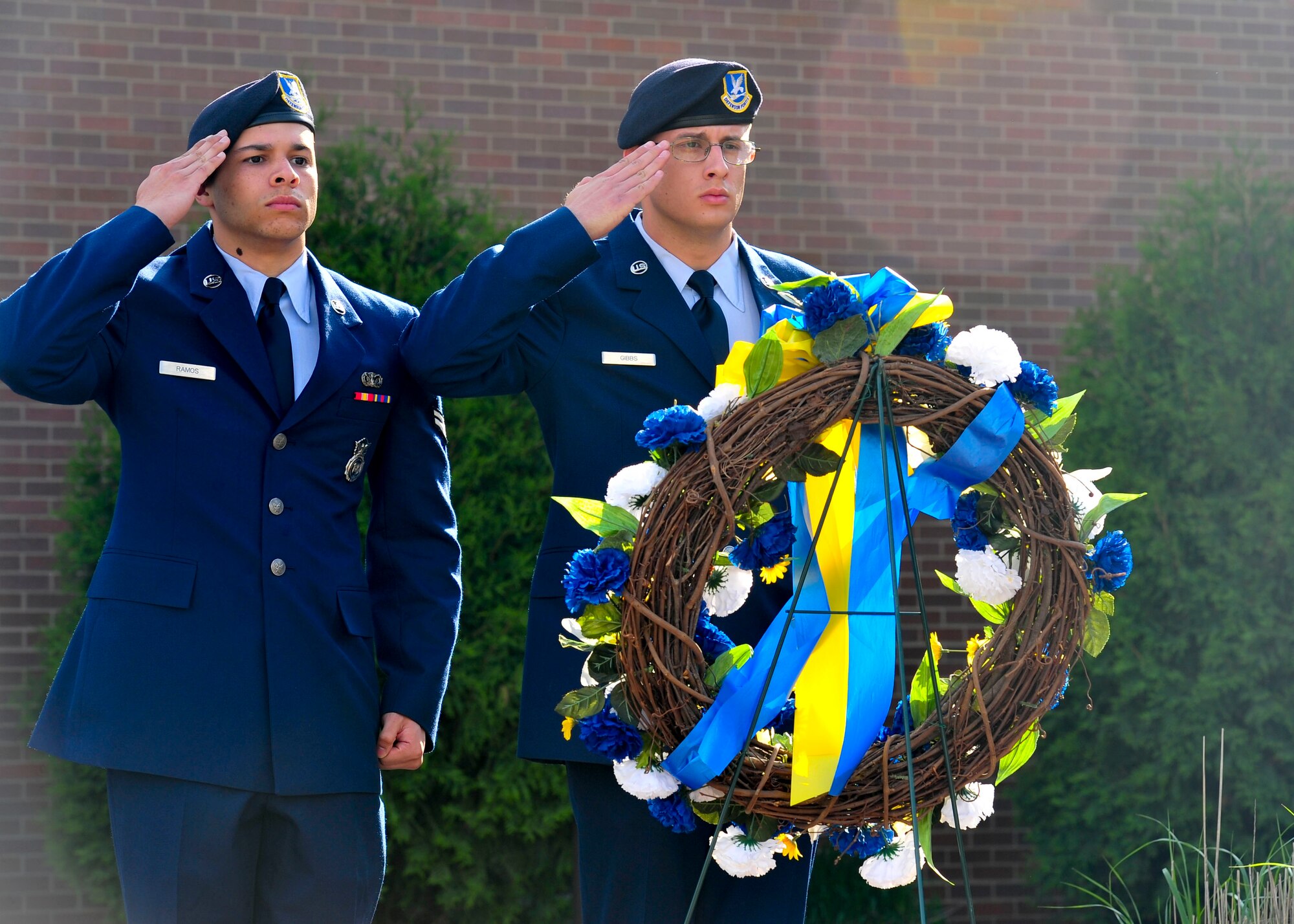 Airman 1st Class Neftali Ramos and Airman 1st Class Thomas Gibbs, assigned to the 514th Security Forces Squadron, part of the 514th Air Mobility Wing at Joint Base McGuire-Dix-Lakehurst, salute a peace officer memorial wreath at the 910th Airlift Wing headquarters flag pole on Youngstown Air Reserve Station May 16 during a peace officer memorial ceremony.