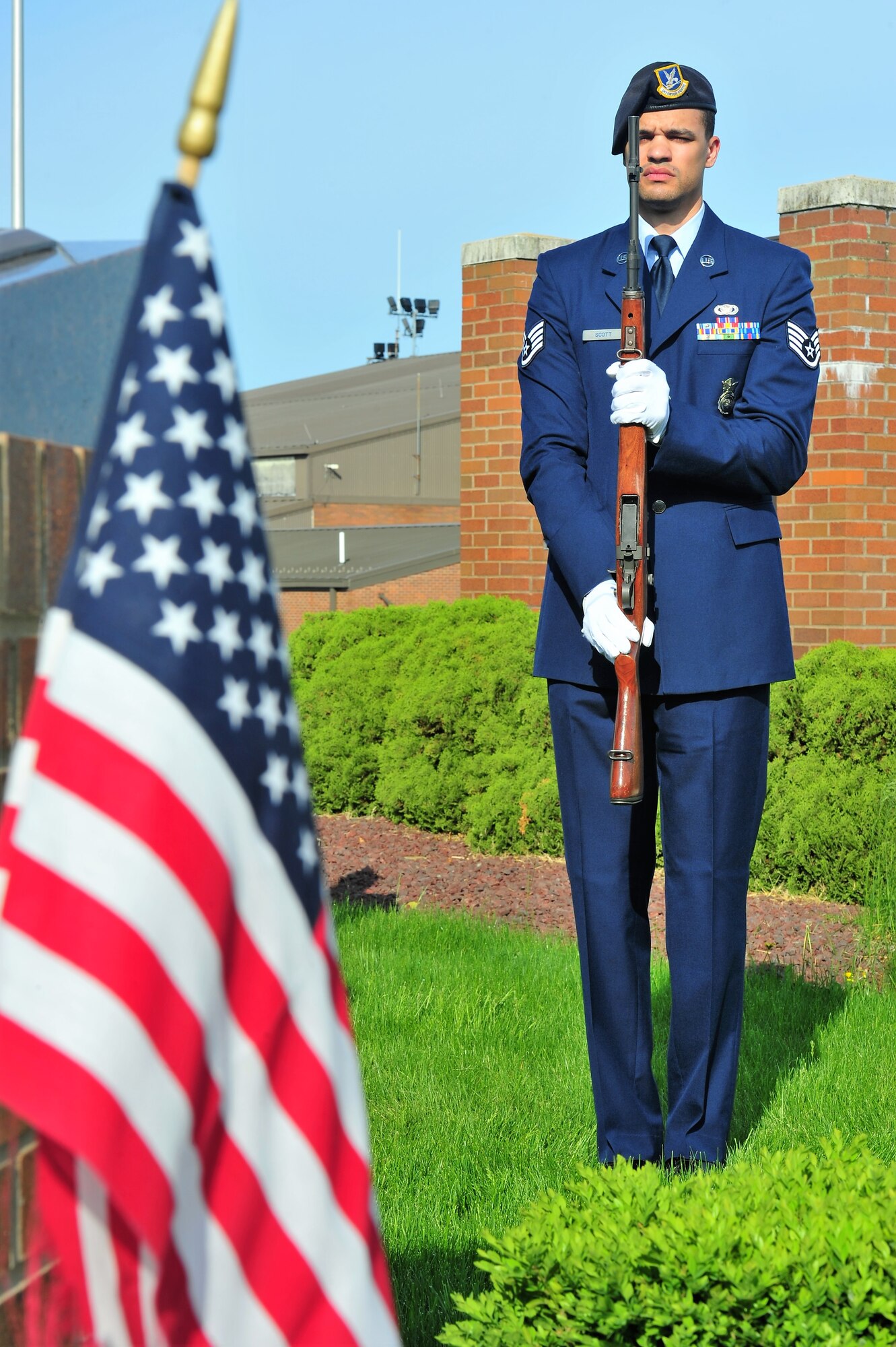 Staff Sgt. Jarrett Scott, a member of the 910th Airlift Wing honor guard team, salutes with his rifle to the playing of taps at the 910th AW headquarters flag pole on at Youngstown Air Reserve Station May 16 during a peace officer memorial ceremony honoring all peace officers who have fallen in the line of duty.