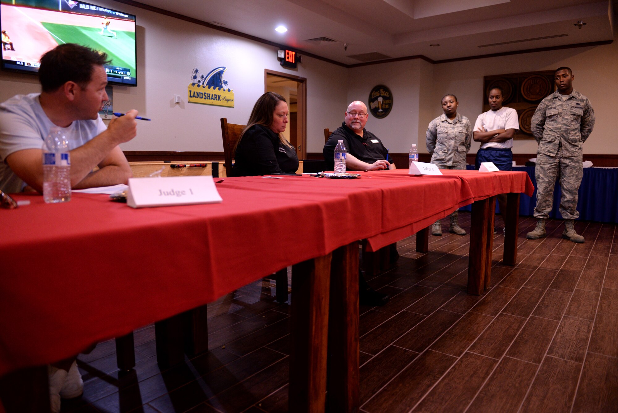 A team of competitors waits hear the results from the judges during the Taste of Luke cooking competition at Luke Air Force Base, Ariz., May 9, 2018. Three teams competed to cook the best three-course meal in a full-service kitchen with fresh ingredients. (U.S. Air Force photo by Senior Airman Ridge Shan)